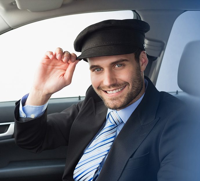 A smiling Cabidz driver in a captain's cap, touching the brim
